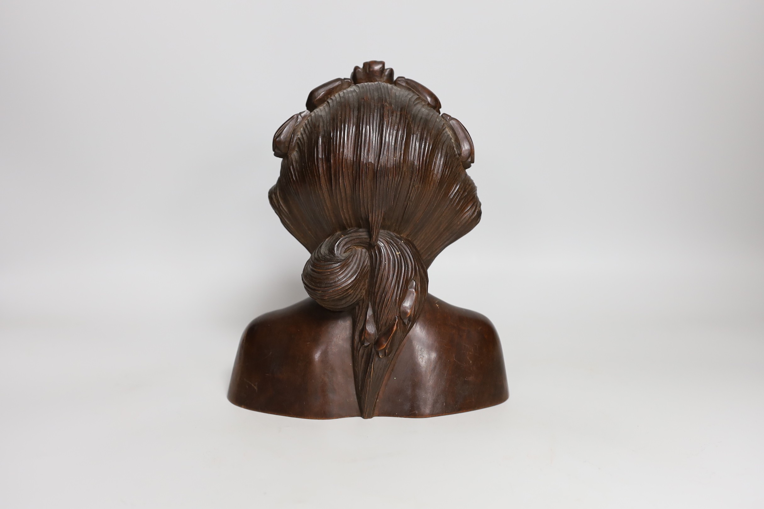 A Balinese carved wood bust, 22cm tall
